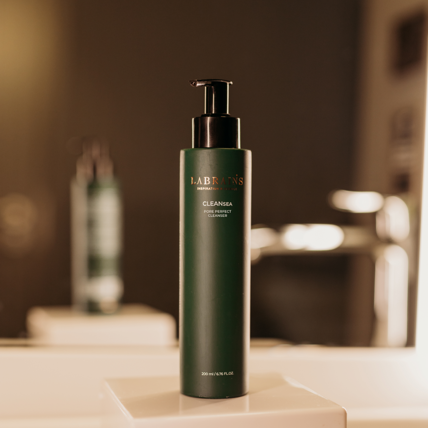 Green bottle of Labrains pore perfect cleanser on a beige bathroom surface, blurred background