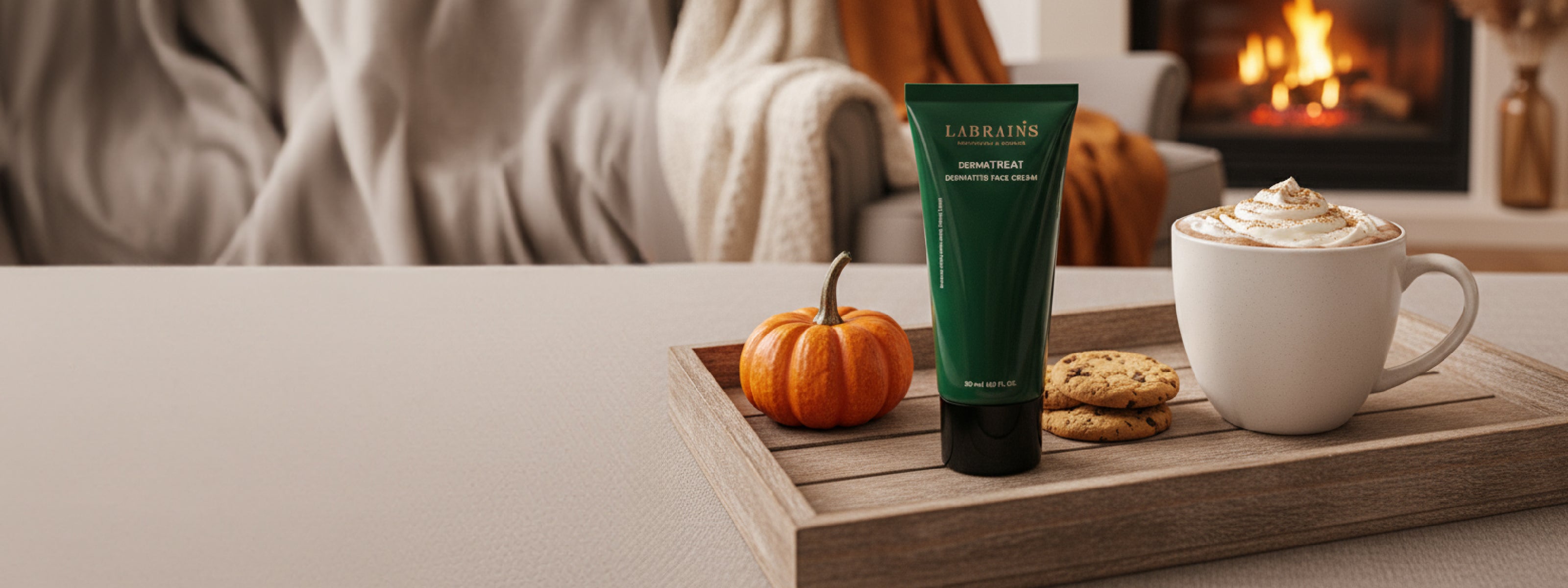 labrains skincare product on a wooden tray with pumpkin, cookies, and a mug of hot chocolate in a cozy fall setting
