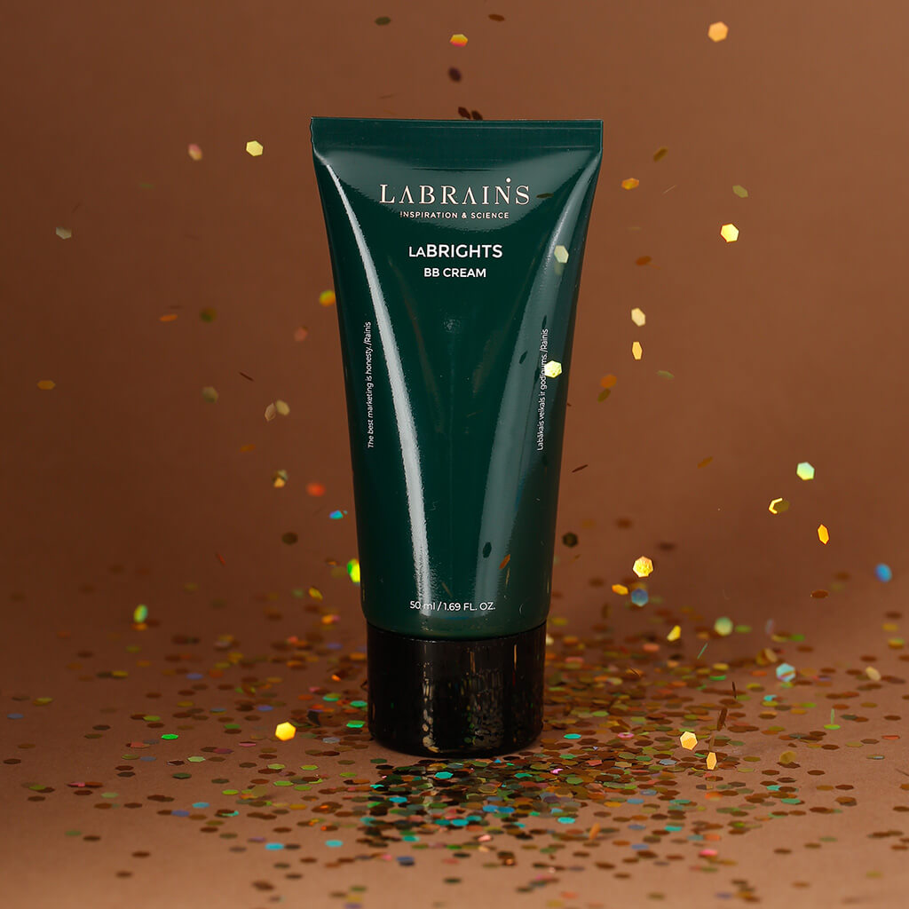 labrains bb cream tube with glitter pouring over it on a brown background