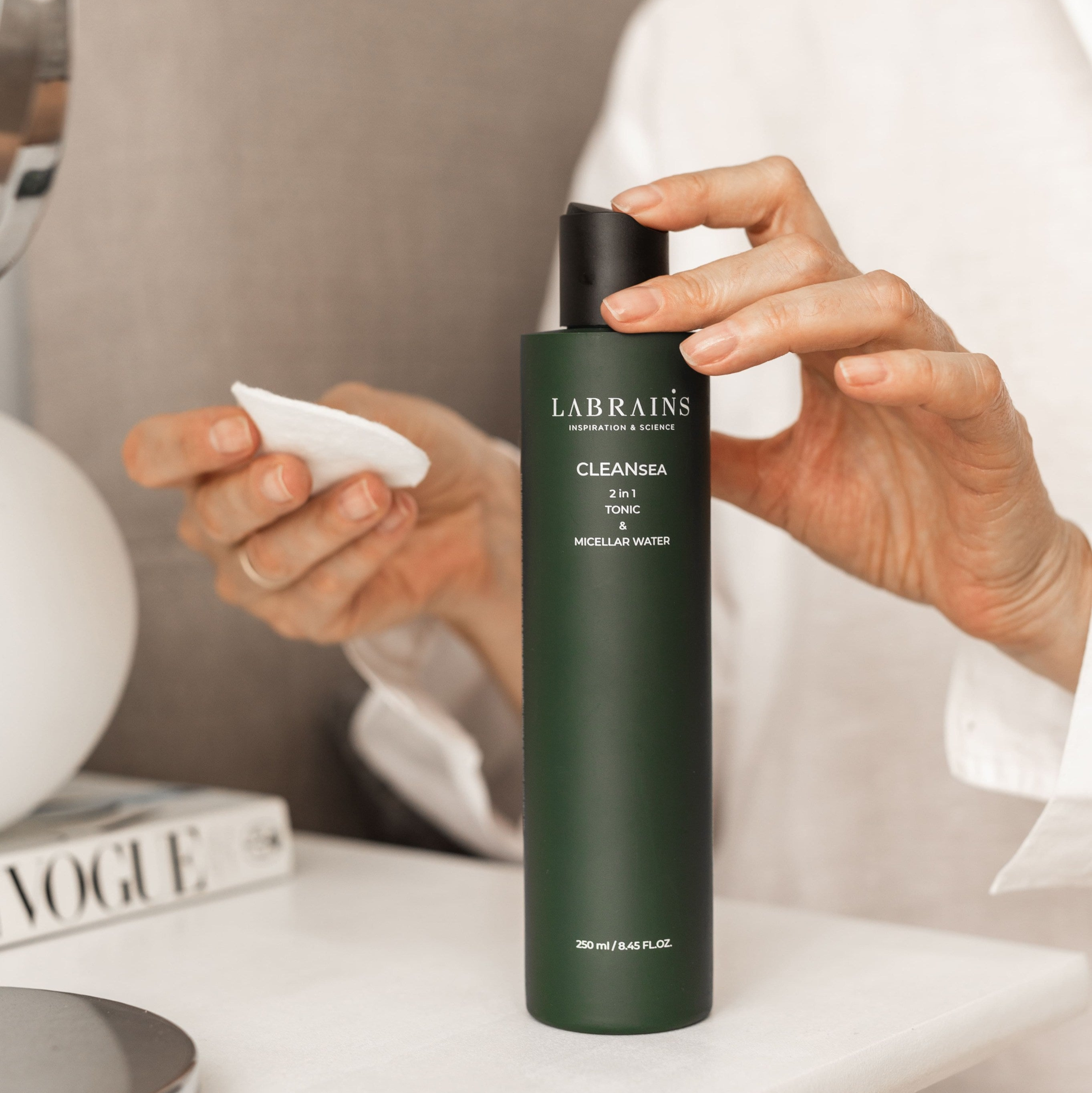 Woman’s hands holding LABRAINS micellar water & tonic during skincare routine