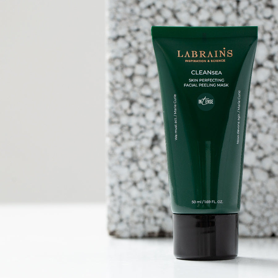 Tube of Labrains' Cleansea Skin Perfecting Facial Peeling Mask Intense, featuring a dark green body and a black cap, set against a textured white and gray stone background.