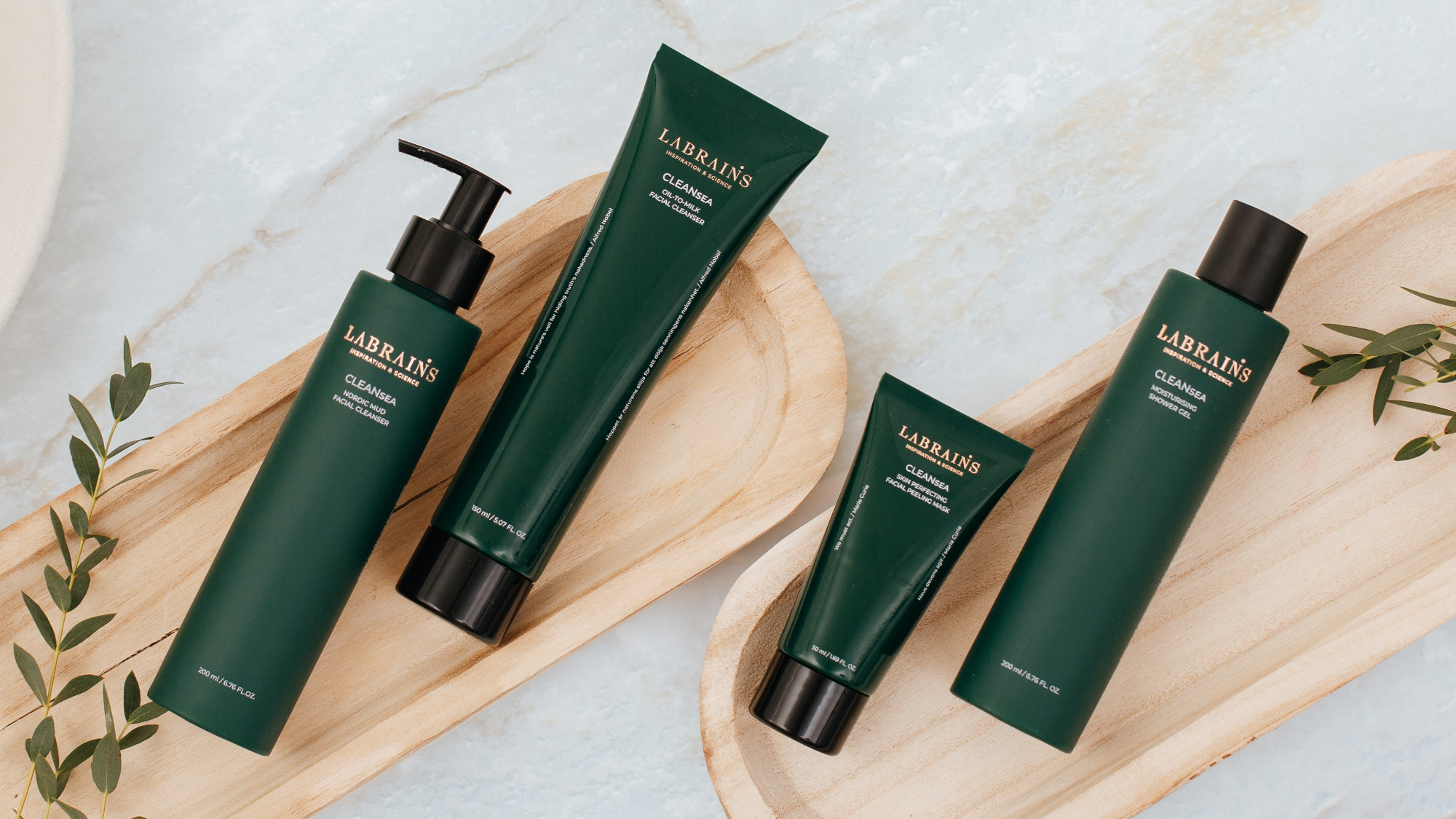 Set of Labrains CleanSea skincare products for skin cleansing on a wooden tray with a light marble background