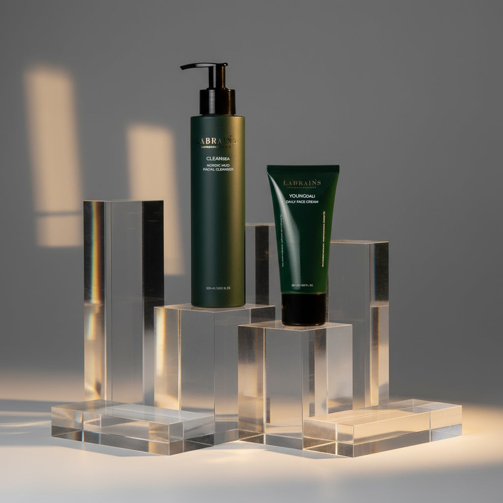 Two labrains skincare products, nordic mud cleanser and youngdali cream, on transparent stands with a dark background